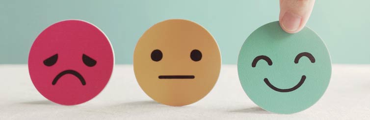 Paper cutout faces showing positive, negative and neutral emotions.