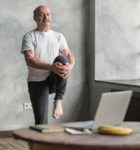 Older man working out in front of his desk.