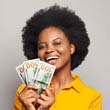 Woman smiling and holding three $100 bills.