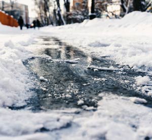  Icy sidewalk with snow on either side.