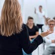 View is from behind an instructor looking out to a room of class attendees.